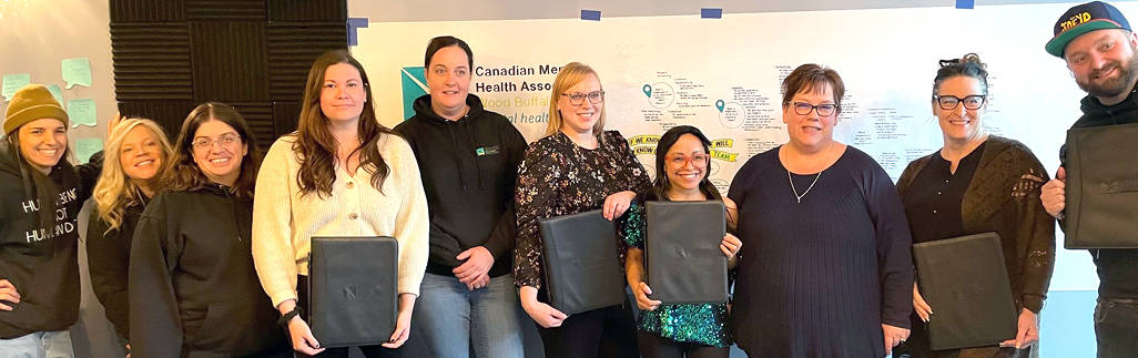 A group of colleagues holding logoed zippered portfolios.