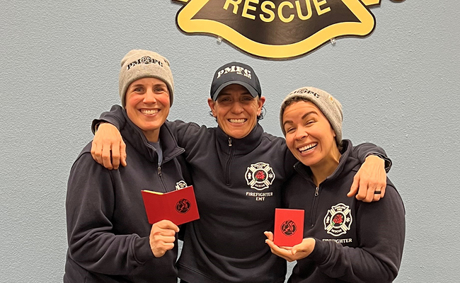 three fire camp attendees holding sticky book promotional product
