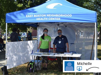 Blue branded canopy with two people and table underneath