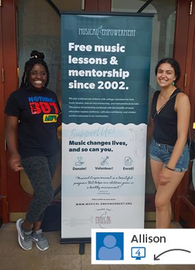 Two people standing by branded stand-up banner