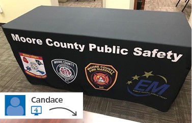 Black table throw branded with "Moore County Public Safety"