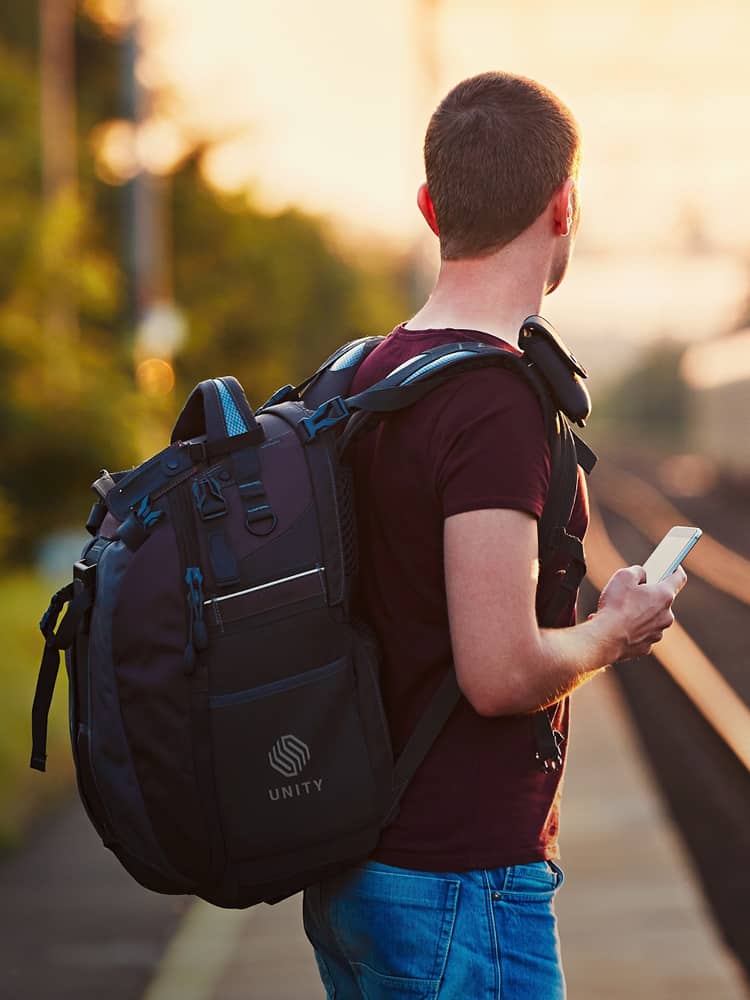 Person waiting for commuter train wearing laptop bag for employee.