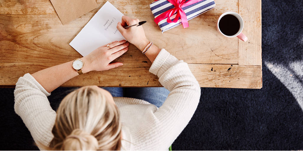 Woman addressing birthday card to customer