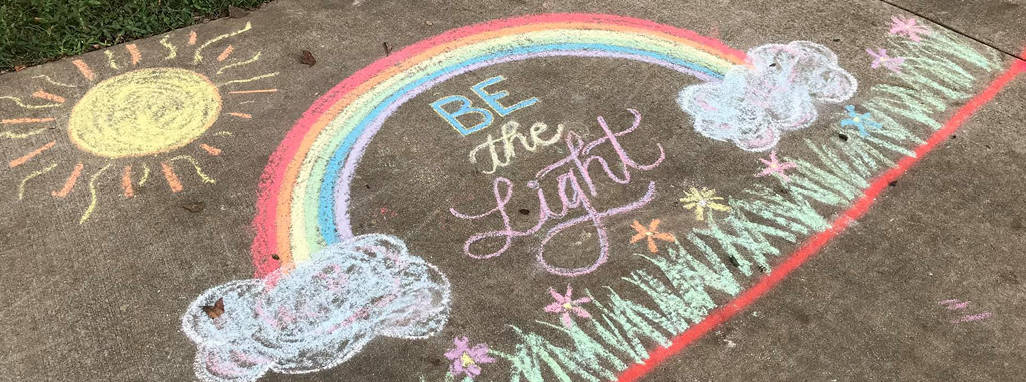 Chalk artwork design of rainbow and sun with words - Be the Light