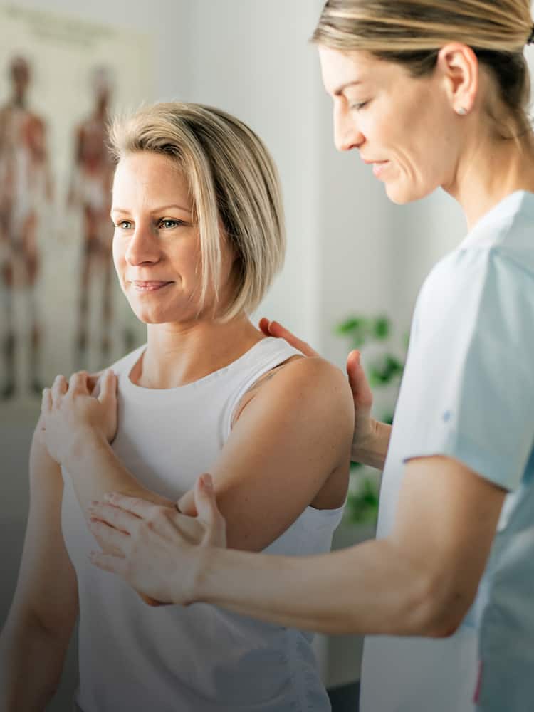 One woman performing physical therapy on another woman