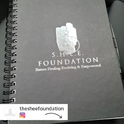 A dark gray notebook with a logo on its cover.