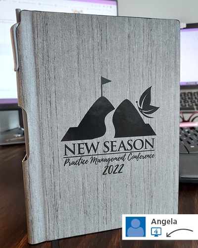 A gray notebook with a logo on its cover.