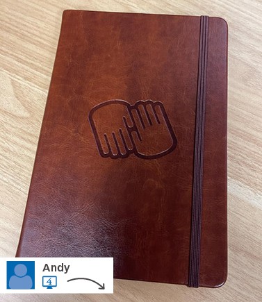 A brown notebook with a logo on its cover.