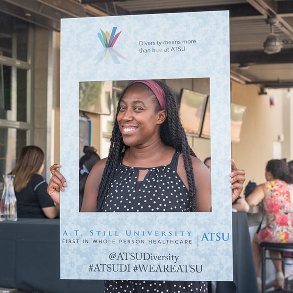 African-American Woman holding up a sign promoting diversity for ATSU