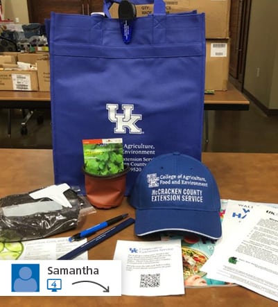 branded bag with contents of bag laying in front - hat, pens, seed packet, etc.