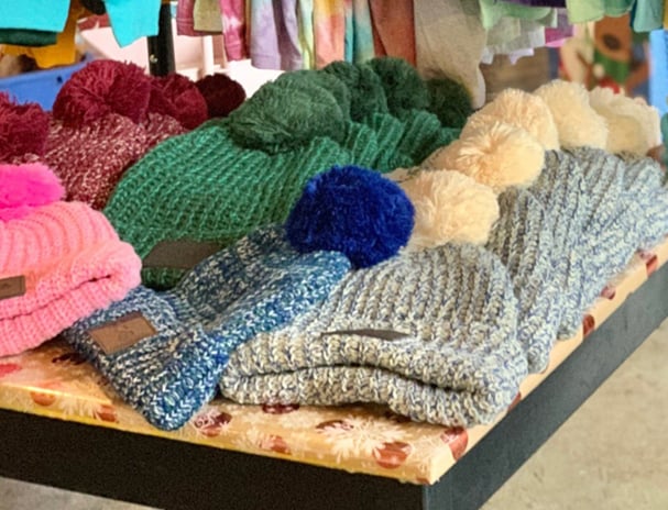 table filled with branded winter hats for sale 