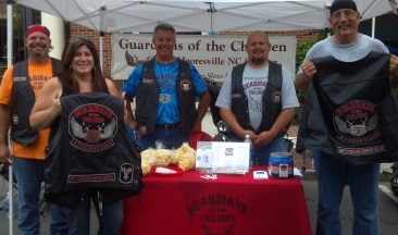 Guardians of the Children volunteers staffing a booth with nonprofit promotional items.