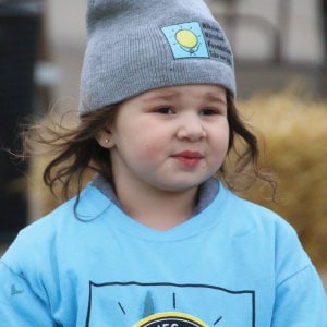 Young child wearing a branded beanie and a blue branded T-shirt