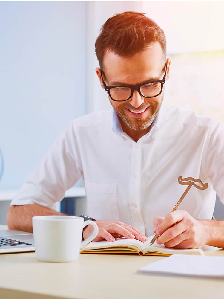 A person writes with a promotional pen from No-Shave November