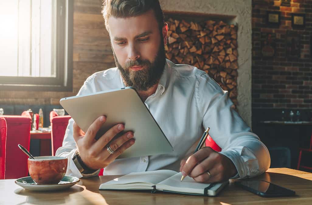 A man with a beard sitting at a desk.