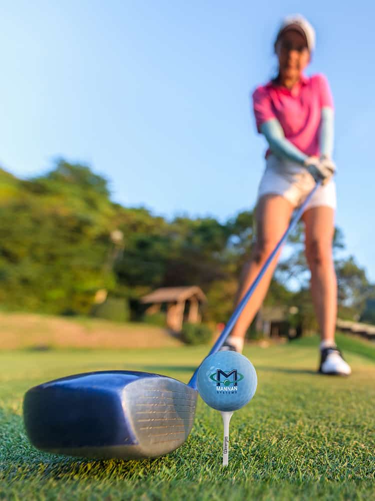 A golfer about to hit a logoed ball.