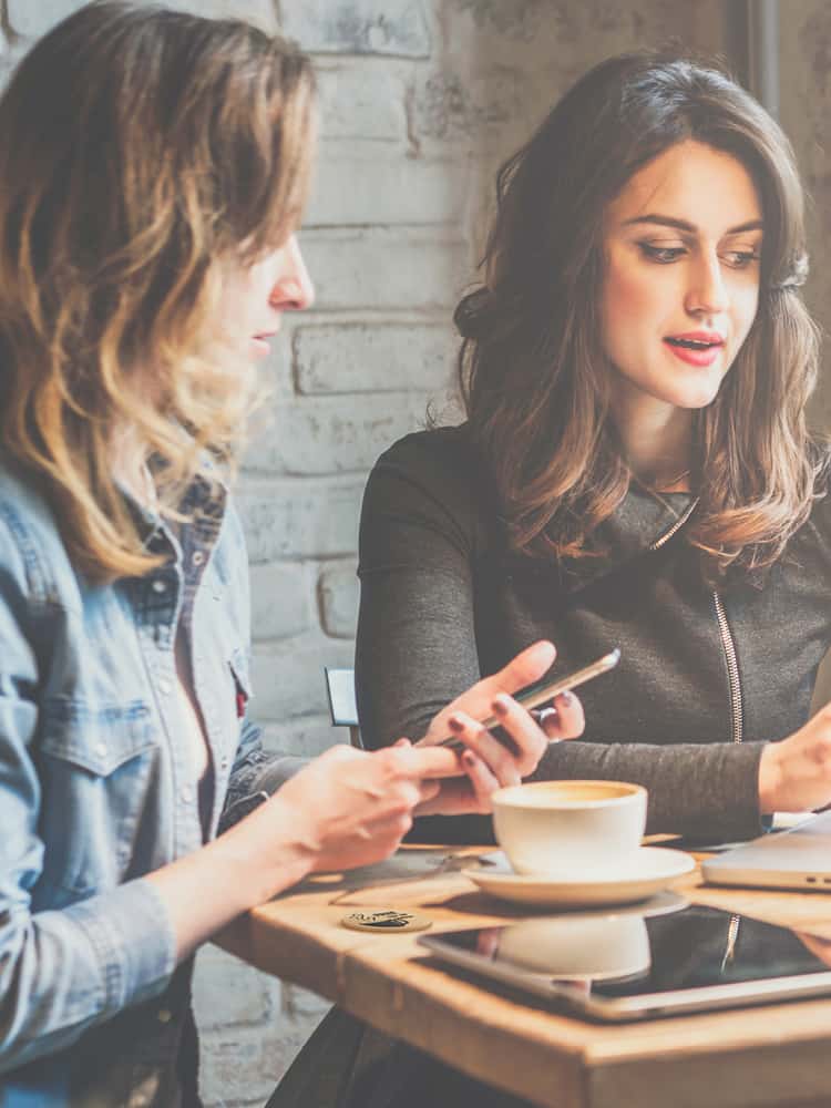 Two women discussing business over a cup of coffee.