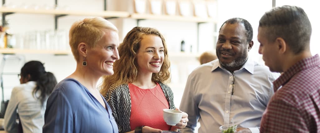 Group of people talking at business gathering.