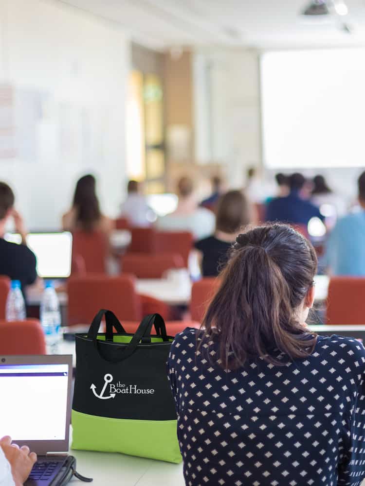 Person attending technology event with a branded bag sitting on the table.