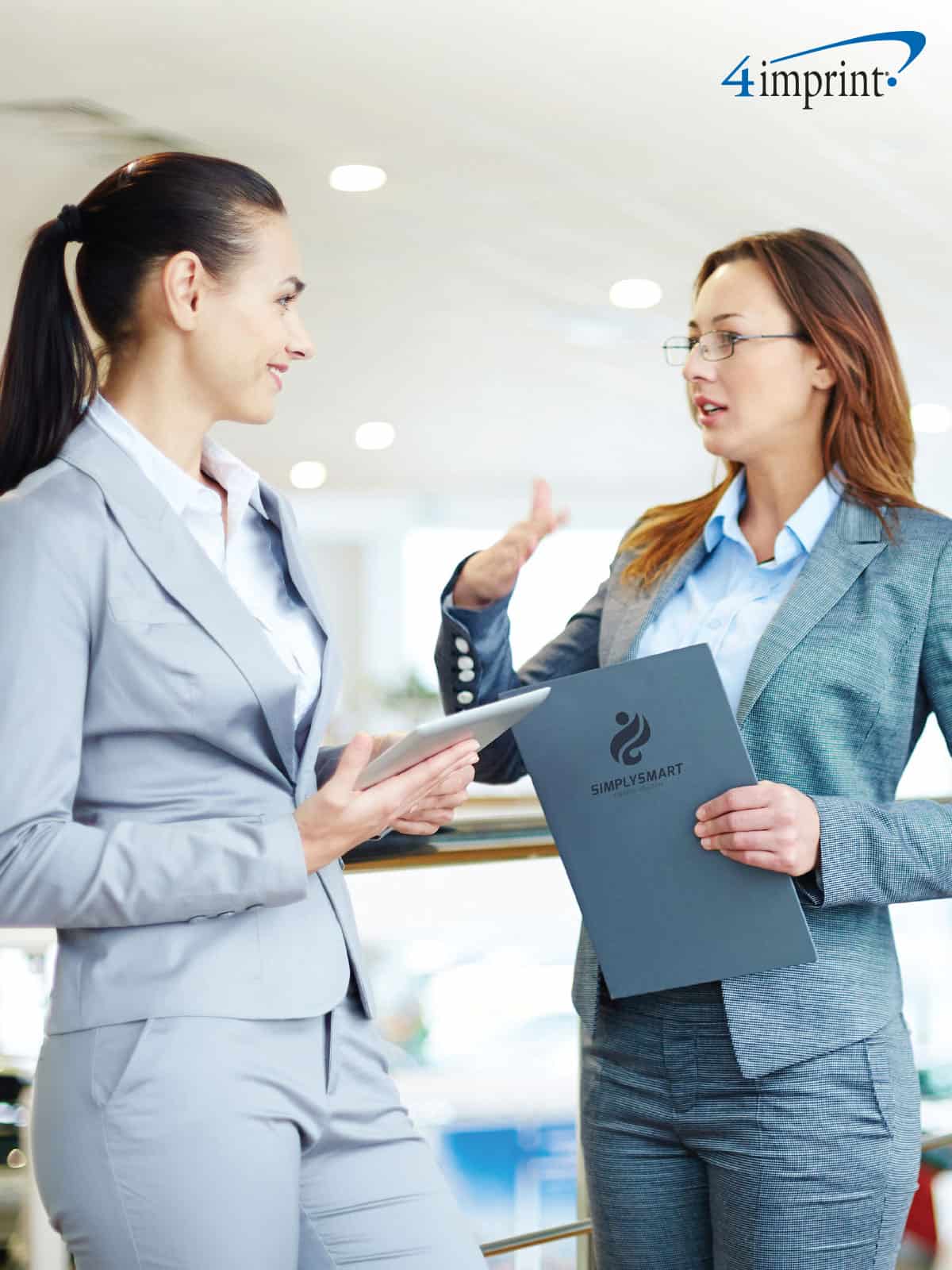 Two women talking at a trade show.