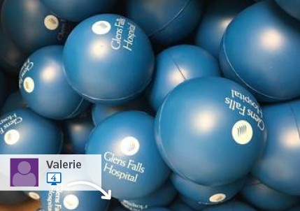 A social media post of blue circle promotional stress balls with Glens Falls Hospital logos on them