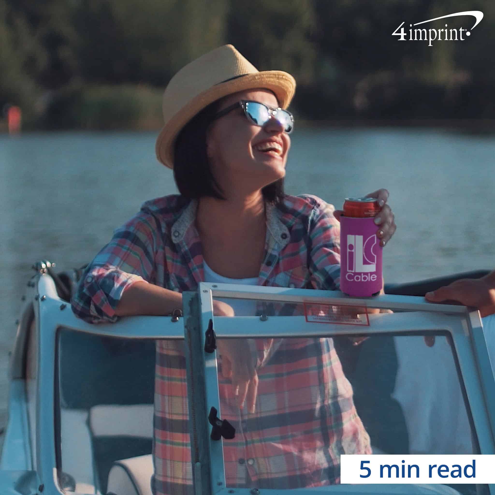 A woman sitting on a boat holding a drink in a promotional can cooler.