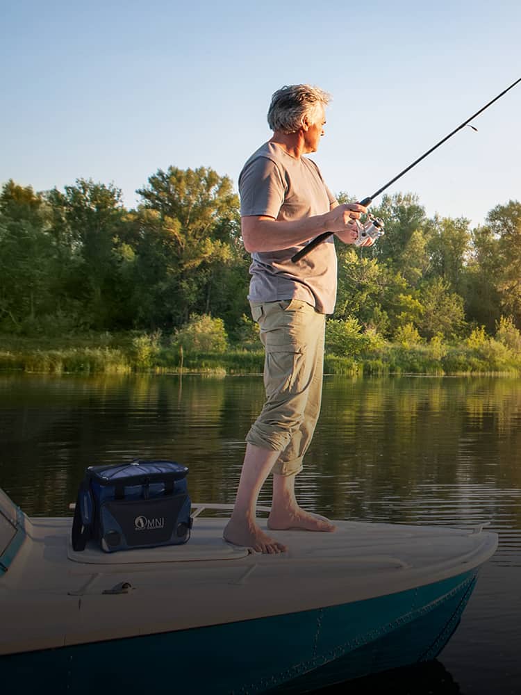 A man fishing next to a cooler.