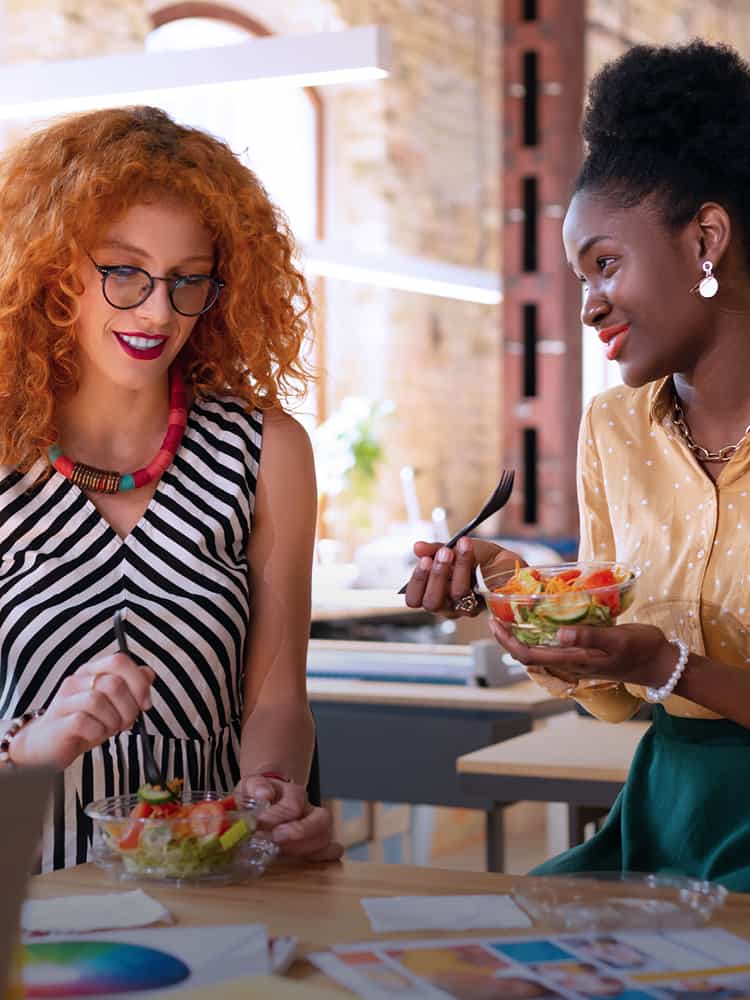 Two women eating a healthy lunch at work