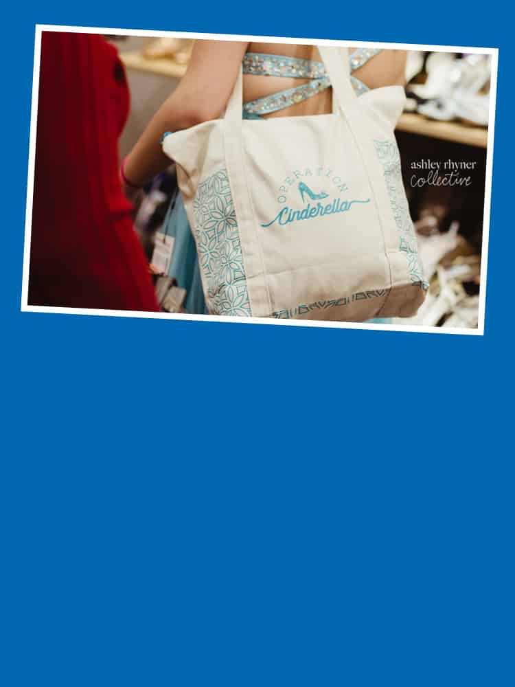 A person in a prom dress holding a branded bag
