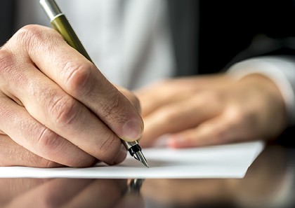 A person writes on a piece of paper