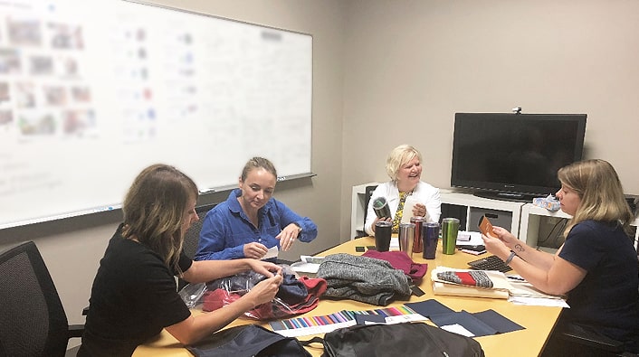 4imprint merchandising team looking over new Crossland promotional fleece line.