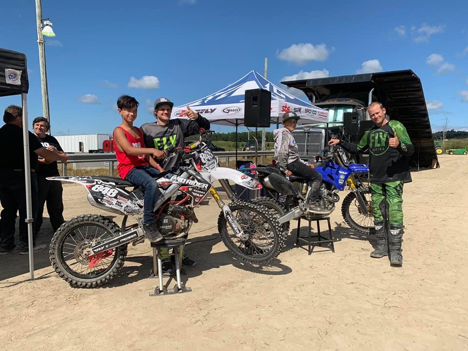 Motocross racers posing with bikes